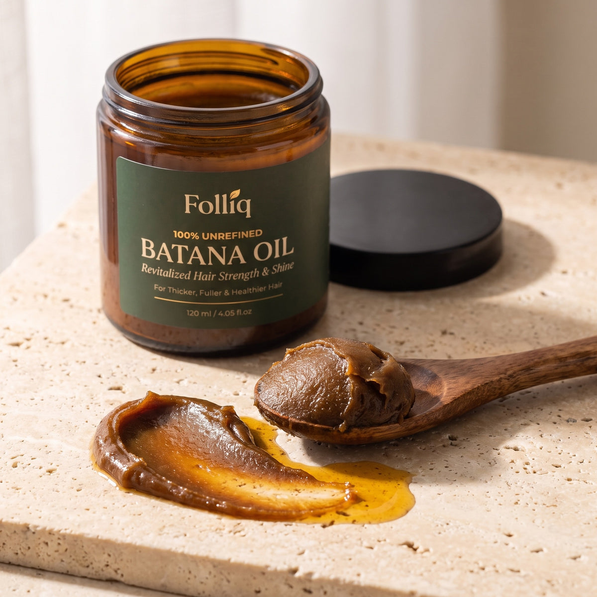 Texture of Folliq unrefined batana paste melting into oil on a wooden spoon