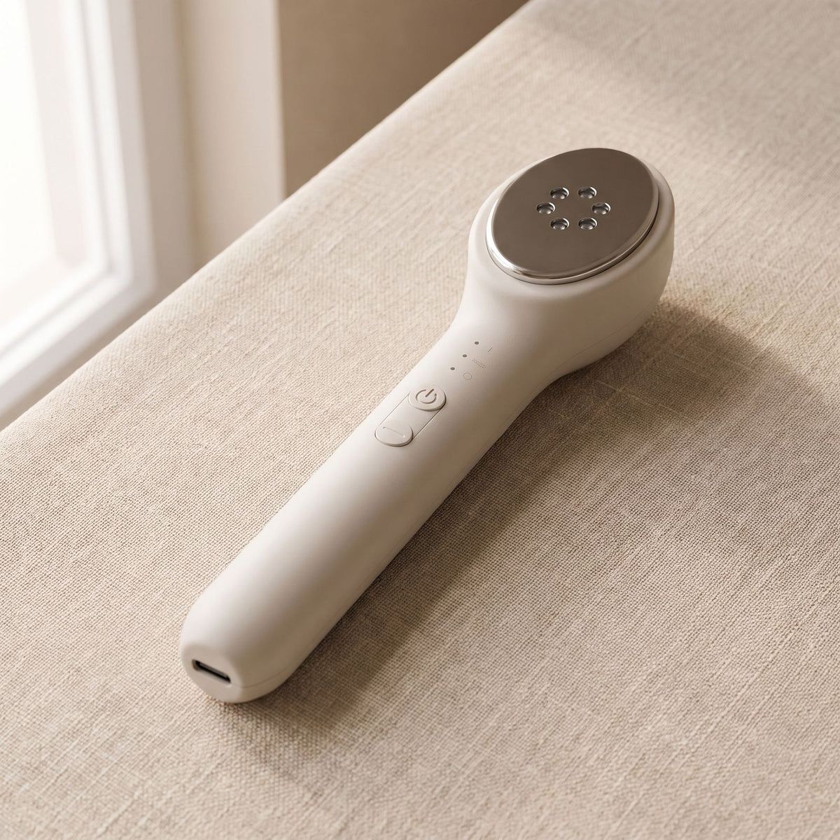 Folliq LED Face Wand with its LEDs off: power and mode buttons and three indicator lights on the handle