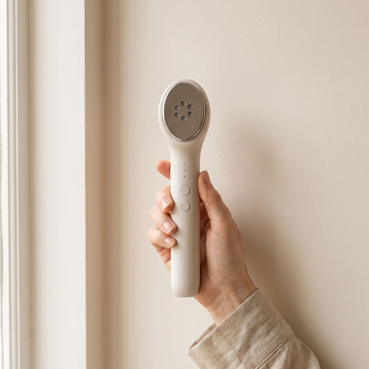 Hand holding the Folliq LED Face Wand, showing its size