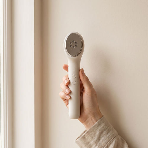 Hand holding the Folliq LED Face Wand, showing its size