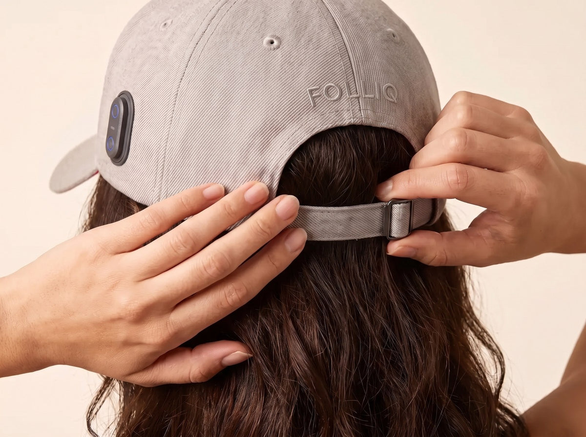 Hands adjusting the strap at the back of the Folliq cap