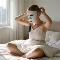 Woman adjusting the strap of the Folliq Red Light Therapy Face Mask