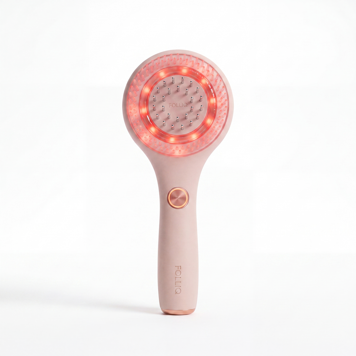 The Folliq Red Light Scalp Massager in blush pink, standing upright with its red LED ring lit