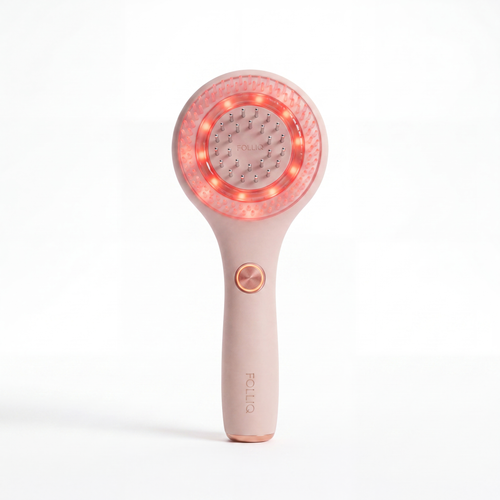 The Folliq Red Light Scalp Massager in blush pink, standing upright with its red LED ring lit