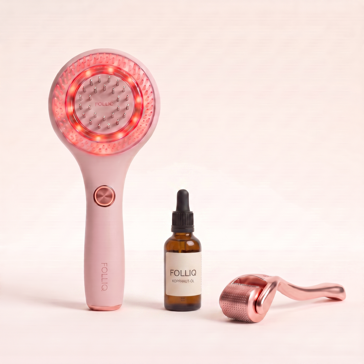 The Folliq massager beside the rosemary serum dropper bottle and the titanium derma roller
