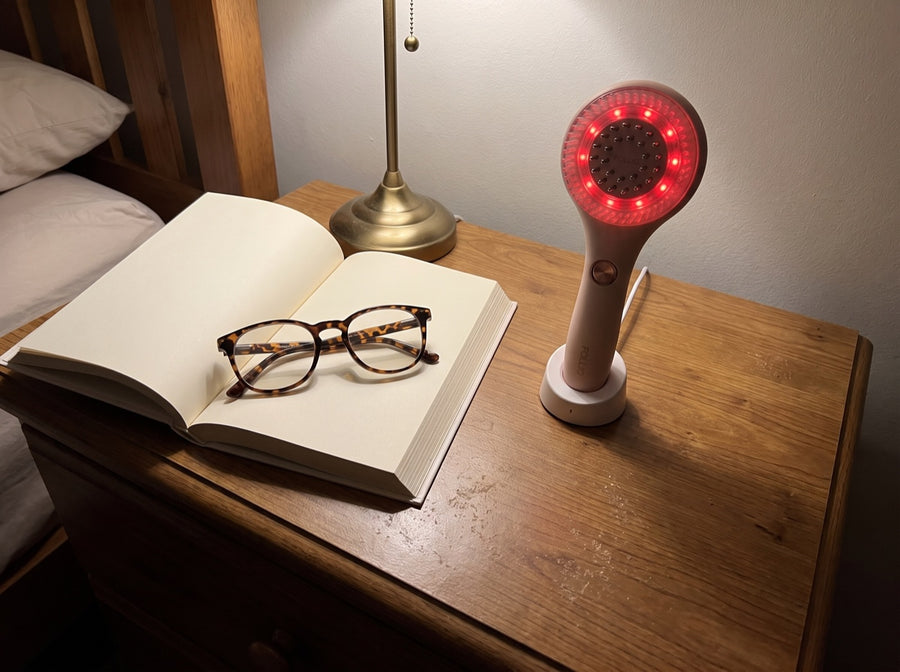 The massager on its stand on a bedroom dresser